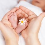 Babyfüße in einer Hand