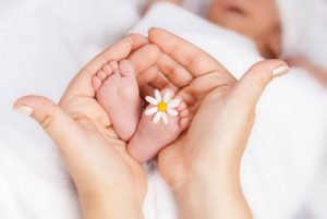 Babyfüße in einer Hand