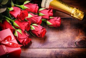 Rote Rosen mit Geschenk und Sekt