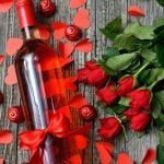 Rosen mit einer Flasche Rotwein