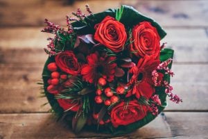 Blumebouquet mit roten Rosen und Deko