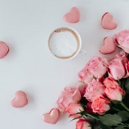 Rosa Rosen mit einer Tasse Kaffee und Herzen